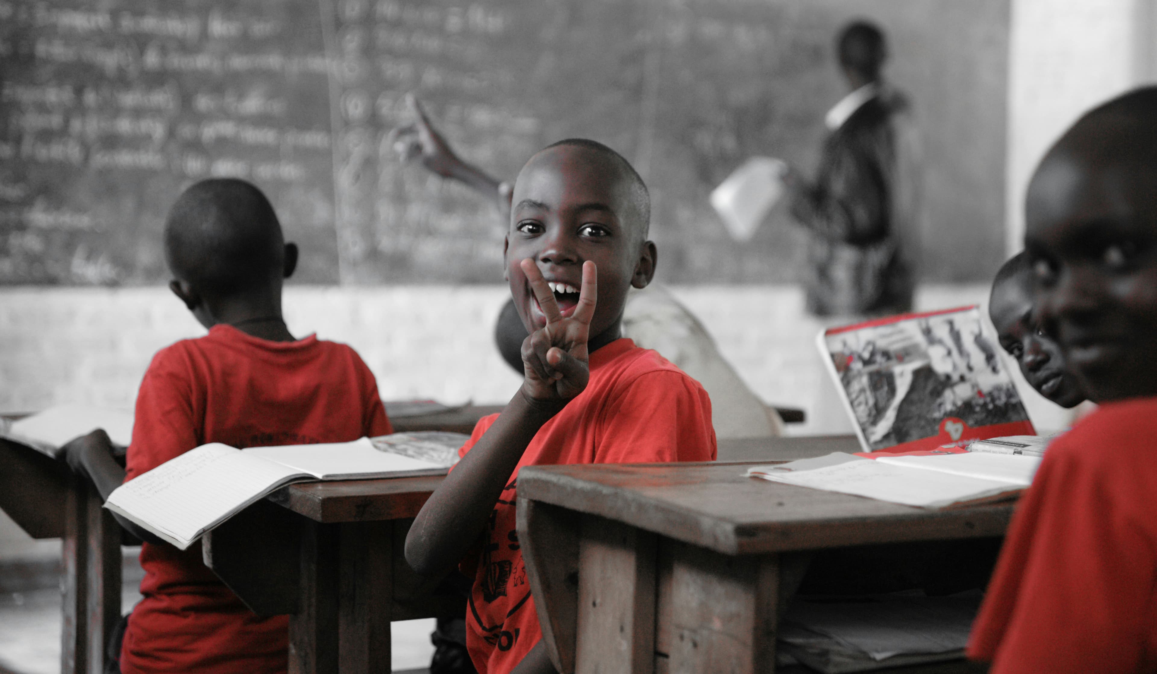 Classroom students smiling by blackboard